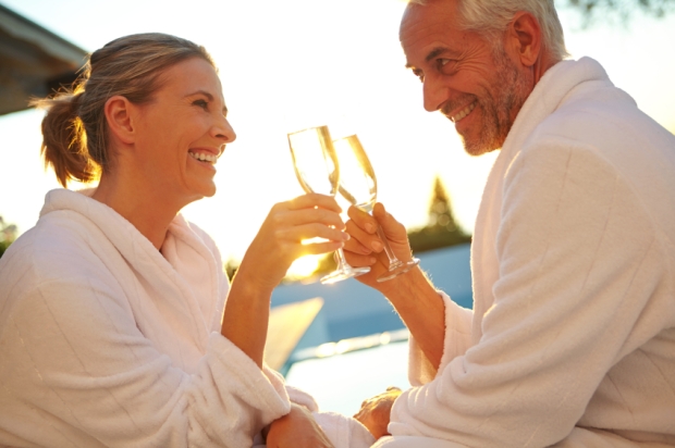 Shot of a mature couple drinking champagne while relaxing in deck chairs at sunset